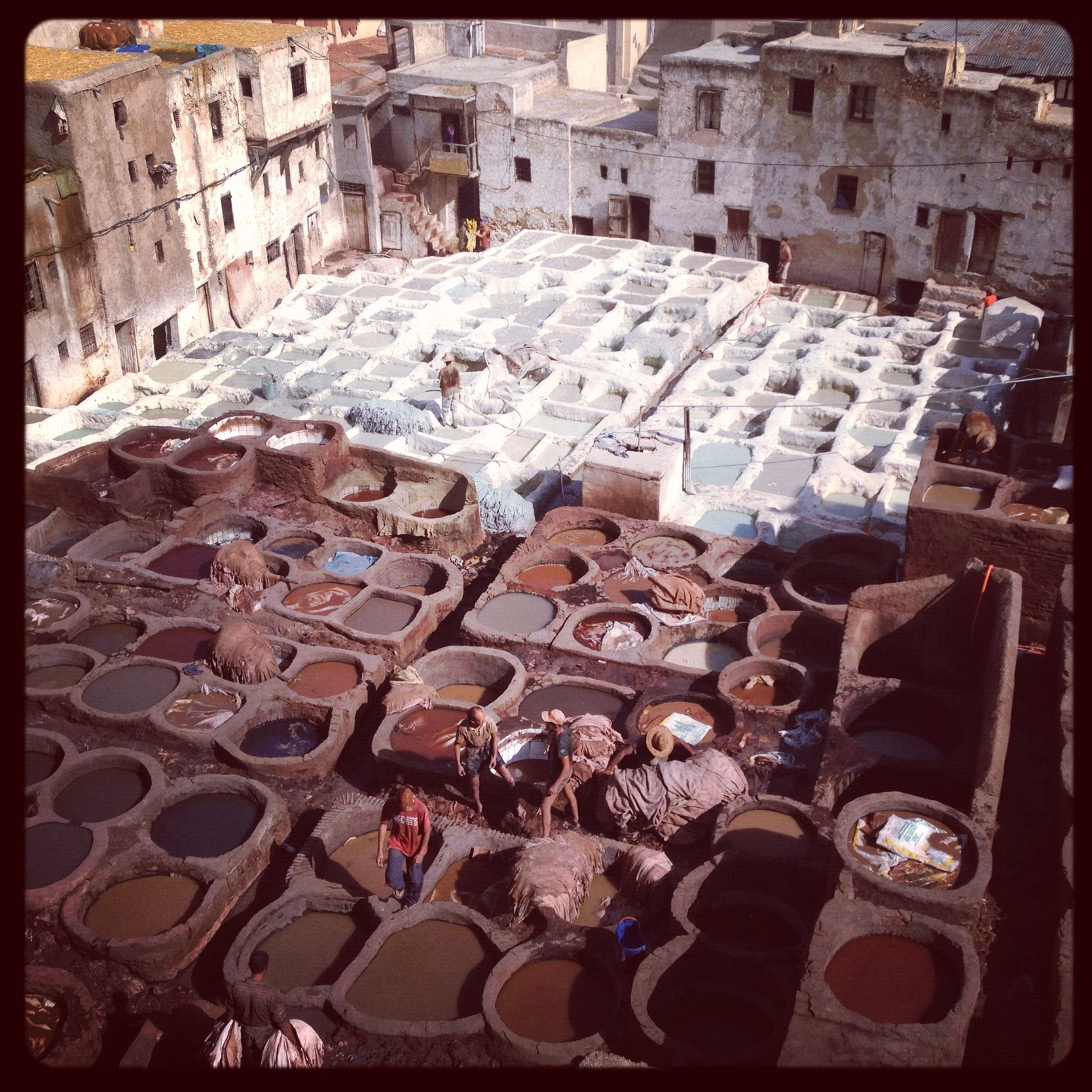 Large stone vats filled with natural dyes in the Chouara Tannery in Fes, Morocco