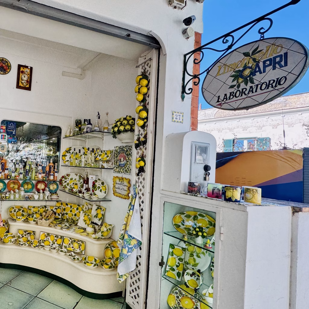Limoncello shop in Anacapri displaying bright lemon-themed ceramics, bottles, and decor under a sign reading “Limoncello Capri Laboratorio”
